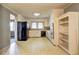Vintage kitchen with dated appliances, white cabinetry and flooring, and black fridge at 6191 Cumming Hwy, Canton, GA 30115