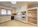 Retro kitchen featuring outdated appliances, worn cabinets, and a patterned floor at 6191 Cumming Hwy, Canton, GA 30115