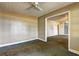 Beige room with a ceiling fan, tan walls, and an open doorway showcasing additional space at 6191 Cumming Hwy, Canton, GA 30115