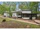 View of the back exterior with a screened-in porch, trees, and a walkway at 6700 Knollwood Cir, Douglasville, GA 30135