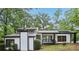 Charming home with a black and white exterior and a cozy front porch and lots of surrounding greenery at 6700 Knollwood Cir, Douglasville, GA 30135