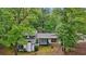 View of the home featuring trees surrounding the property and a stone front at 6700 Knollwood Cir, Douglasville, GA 30135