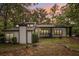 Exterior view of the home with front porch surrounded by mature trees at 6700 Knollwood Cir, Douglasville, GA 30135