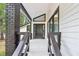 Inviting covered front porch with brick column and painted wood deck at 6700 Knollwood Cir, Douglasville, GA 30135