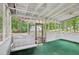 Relaxing screened-in porch featuring a swing and view of the trees surrounding the property at 6700 Knollwood Cir, Douglasville, GA 30135
