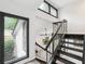 Bright foyer with black framed windows flanking a modern staircase with dark wood railings at 6700 Knollwood Cir, Douglasville, GA 30135