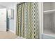 Updated bathroom includes modern shower with decorative shower curtain and shelving for storage at 6802 Ida St, Lithonia, GA 30058