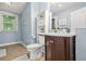 Cozy bathroom with blue walls, updated vanity, with open shelving for easy access at 6802 Ida St, Lithonia, GA 30058