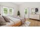 Inviting bedroom with hardwood floors, large windows, and a stylish dresser at 6802 Ida St, Lithonia, GA 30058