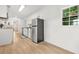 Modern kitchen with stainless steel fridge, white cabinets and hardwood floor at 6802 Ida St, Lithonia, GA 30058