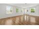 Bright living room with hardwood floors, white walls, and natural light from large windows at 6802 Ida St, Lithonia, GA 30058