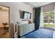 Cozy bedroom with natural light features a decorative dresser, a TV, and a comfy blue bed at 800 Peachtree Ne St # 1014, Atlanta, GA 30308