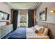 Comfortable bedroom with backyard views features an artistic dresser, a flat screen TV, and modern décor at 800 Peachtree Ne St # 1014, Atlanta, GA 30308