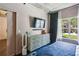 Bright bedroom with backyard views features a modern dresser, a flat screen TV, and access to an ensuite bathroom at 800 Peachtree Ne St # 1014, Atlanta, GA 30308