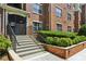 Building entrance with gated access, featuring well-maintained landscaping and steps leading to the lobby at 800 Peachtree Ne St # 1014, Atlanta, GA 30308