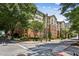 Apartment building exterior featuring lush trees, a brick facade, and multiple stories of residential units at 800 Peachtree Ne St # 1014, Atlanta, GA 30308