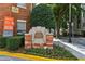 Cornerstone Village signage with brick base, surrounded by colorful flowers and greenery at 800 Peachtree Ne St # 1014, Atlanta, GA 30308