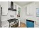 Modern kitchen with white cabinets, stainless steel gas range, and sleek black range hood at 999 Smith Sw St, Atlanta, GA 30310