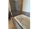 Detail of tub area featuring tile surround and glass shower enclosure at 261 Cole Ne St, Marietta, GA 30060