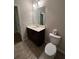 Bright bathroom featuring a single sink vanity, a toilet, and an open doorway at 261 Cole Ne St, Marietta, GA 30060