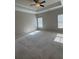 Large carpeted bedroom with tray ceiling, ceiling fan, and two windows for natural light at 261 Cole Ne St, Marietta, GA 30060