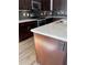 Modern kitchen with stainless steel appliances, dark cabinets, granite countertops, tile backsplash, and hardwood floors at 261 Cole Ne St, Marietta, GA 30060