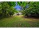 A large grassy backyard surrounded by lush greenery with house in distance at 5310 Arrowind Nw Rd, Lilburn, GA 30047