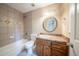 Bathroom features a tiled shower-tub combo, vanity, and oval mirror above the sink at 5310 Arrowind Nw Rd, Lilburn, GA 30047
