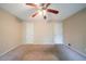 This bedroom features neutral walls and carpet, two doors, and a ceiling fan with a light fixture at 5310 Arrowind Nw Rd, Lilburn, GA 30047