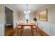 Formal dining room with hardwood floors, wainscoting, a modern chandelier, and a table set for eight at 5310 Arrowind Nw Rd, Lilburn, GA 30047