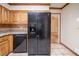 Close-up of a spacious kitchen with black appliances, tiled flooring, and light wood cabinetry at 5310 Arrowind Nw Rd, Lilburn, GA 30047