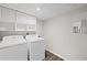 Bright laundry room features a washer, dryer, white cabinets and gray paint at 1415 Dalewood Ne Dr, Atlanta, GA 30329