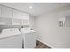 Bright laundry room with washer, dryer, and overhead cabinets for storage at 1415 Dalewood Ne Dr, Atlanta, GA 30329