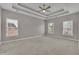 Bedroom with tray ceiling, fan, carpet, and large windows at 1805 Hunters Moon Dr, Alpharetta, GA 30005