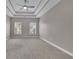 Bedroom featuring tray ceiling, fan, and large windows at 1805 Hunters Moon Dr, Alpharetta, GA 30005