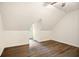 Attic with wood-look floors and a small window overlooking the backyard at 3021 Mills Ridge Dr, Canton, GA 30114