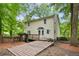 Backyard with a wooden deck, steps, and landscaped features under the shade of mature trees at 3021 Mills Ridge Dr, Canton, GA 30114