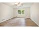 Bright bedroom with wood-look floors, a ceiling fan, and a large window overlooking the backyard at 3021 Mills Ridge Dr, Canton, GA 30114