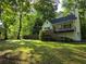 Charming two-story home with a large front yard surrounded by mature trees at 3021 Mills Ridge Dr, Canton, GA 30114
