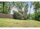 Lovely home with a front porch and stairs nestled among mature trees and a grassy lawn at 3021 Mills Ridge Dr, Canton, GA 30114