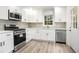 Modern kitchen featuring stainless steel appliances, white cabinets, and tile backsplash at 3021 Mills Ridge Dr, Canton, GA 30114