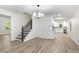 Bright living room with hardwood floors, modern chandelier, staircase, and open view to kitchen at 3021 Mills Ridge Dr, Canton, GA 30114
