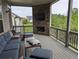 Covered back porch with a stone fireplace, mounted TV, and comfortable seating with a view of a yard at 322 Woodridge Pass, Canton, GA 30114
