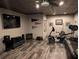 Finished basement featuring wood grain floors, a mounted TV, workout equipment, and comfortable seating at 322 Woodridge Pass, Canton, GA 30114