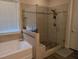 Luxurious bathroom with a glass enclosed shower, pebble floor, and a soaking tub with tile surround at 322 Woodridge Pass, Canton, GA 30114