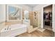 Bright bathroom featuring a soaking tub, glass shower, and ample natural light at 322 Woodridge Pass, Canton, GA 30114