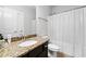 Bright bathroom features granite counters, modern fixtures, and a shower-tub combination with white shower curtain at 322 Woodridge Pass, Canton, GA 30114