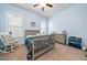 Bright bedroom with light blue walls, ceiling fan, rocking chair and window at 322 Woodridge Pass, Canton, GA 30114