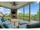 Covered outdoor patio with stone fireplace, TV, seating and nature views at 322 Woodridge Pass, Canton, GA 30114