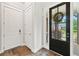 Welcoming entryway with a stylish black front door, coat closet, and hardwood floors at 322 Woodridge Pass, Canton, GA 30114